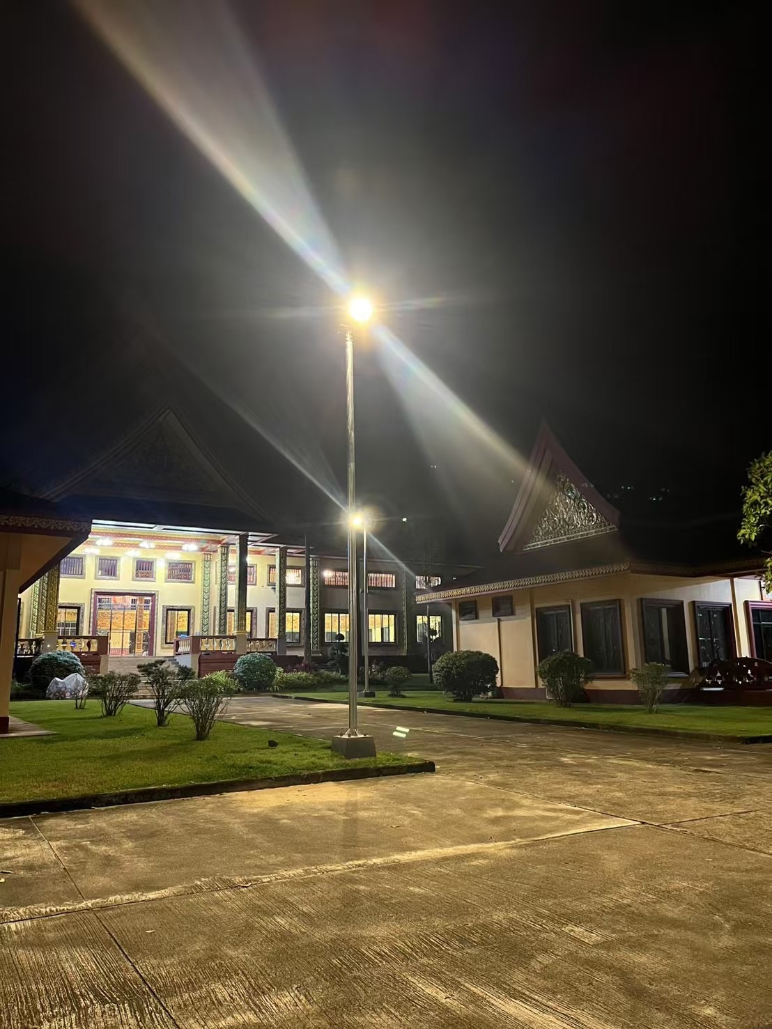 AOK SD solar street light installation providing night-time illumination on an outdoor roadway in Thailand