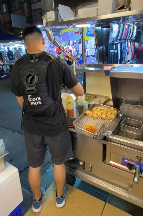 Vendedor de mercado noturno usando colete de arrefecimento