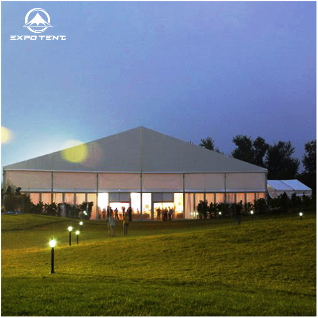 Event tent installed outdoors for a gathering, with furniture arranged inside the covered area
