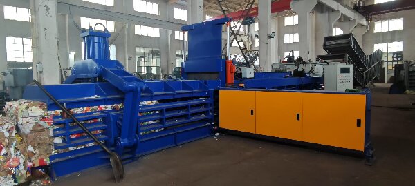 Waste paper hydraulic baler machine in a recycling facility