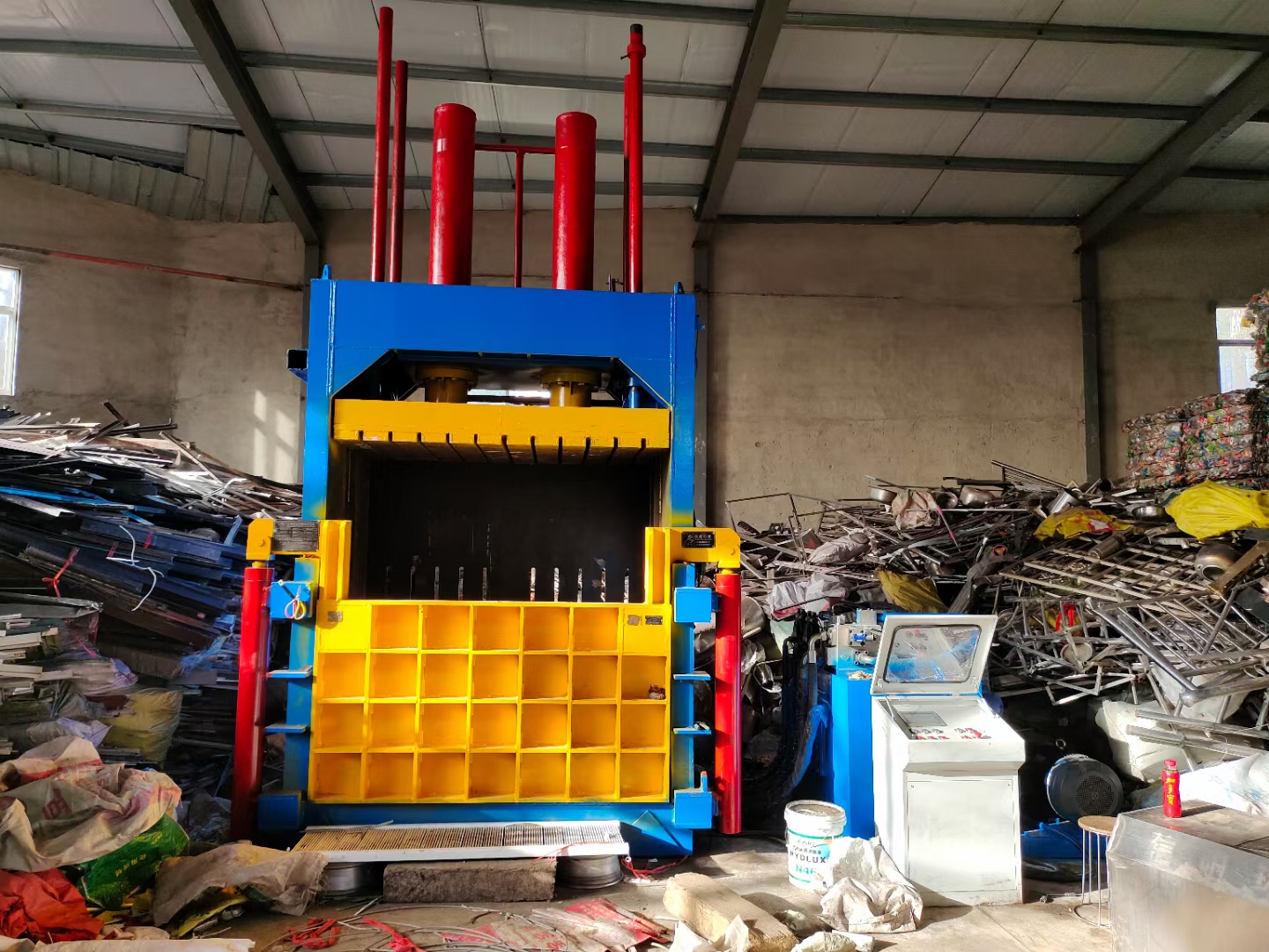Vertical metal baler used for compacting metal scrap into dense bales