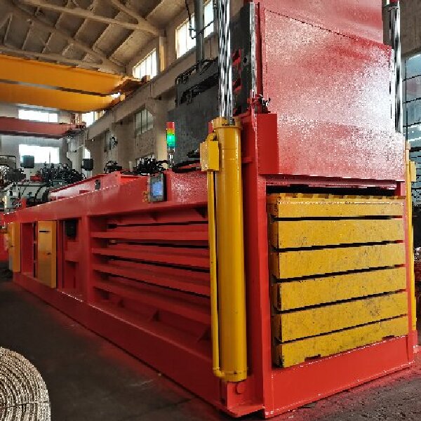 Semi-automatic horizontal hydraulic baler prepared for inspection and documentation review