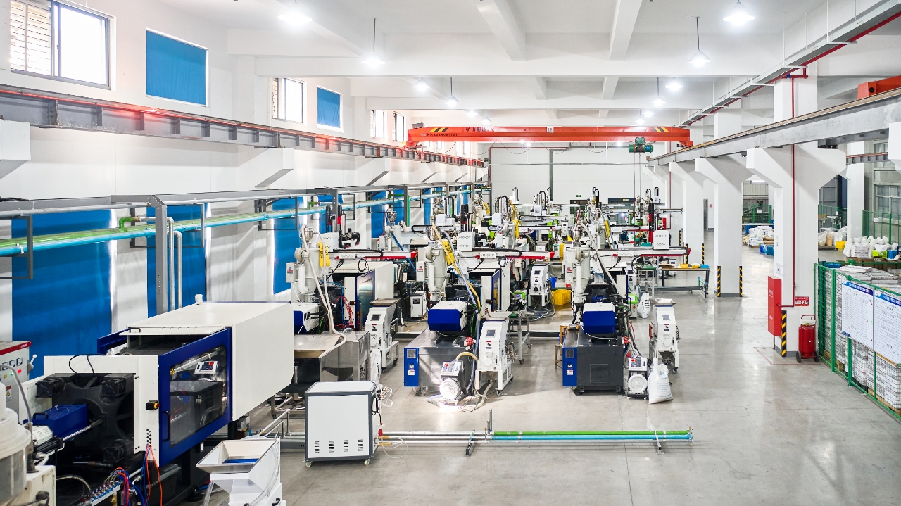 Injection molding workshop at Ningbo Jinmi showing rows of machines