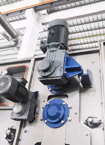 Textile washing machine roller drive using a reducer for continuous fabric transport