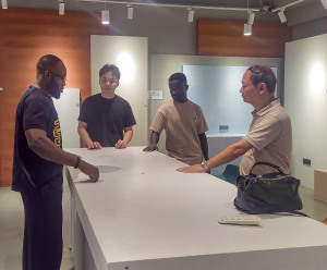A client from Ghana examines a countertop finished with micro-cement.