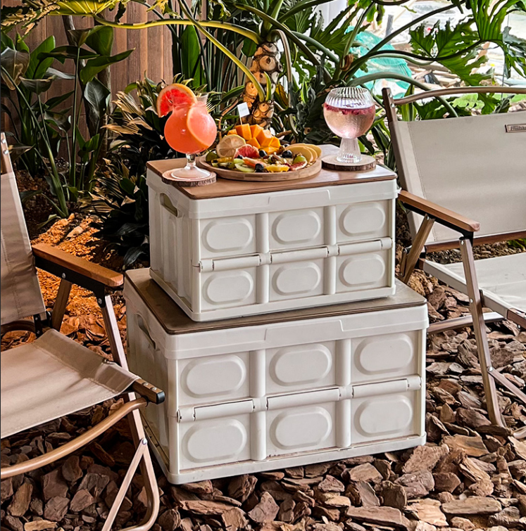 Foldable camping storage box with wooden lid used as outdoor table