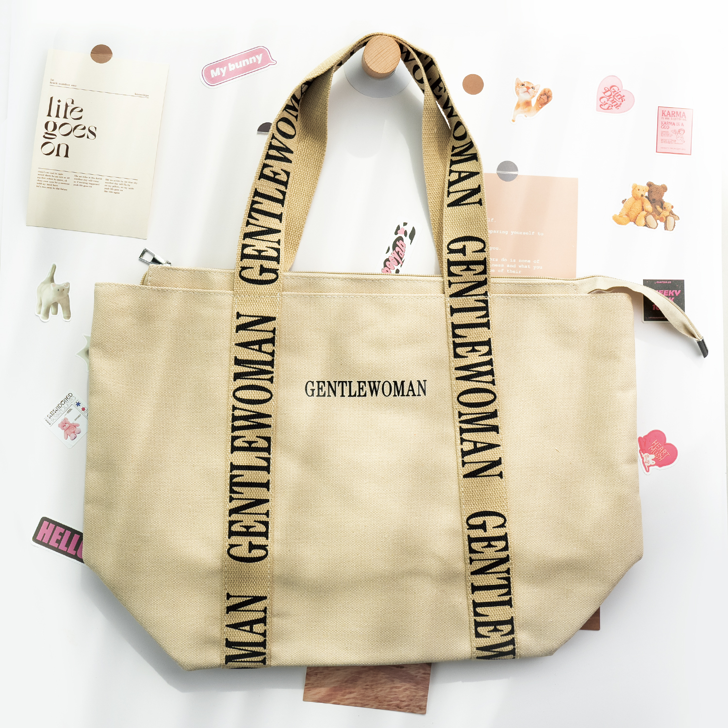 Beige canvas tote bag with letter-printed webbing handle, ideal for brand promotions