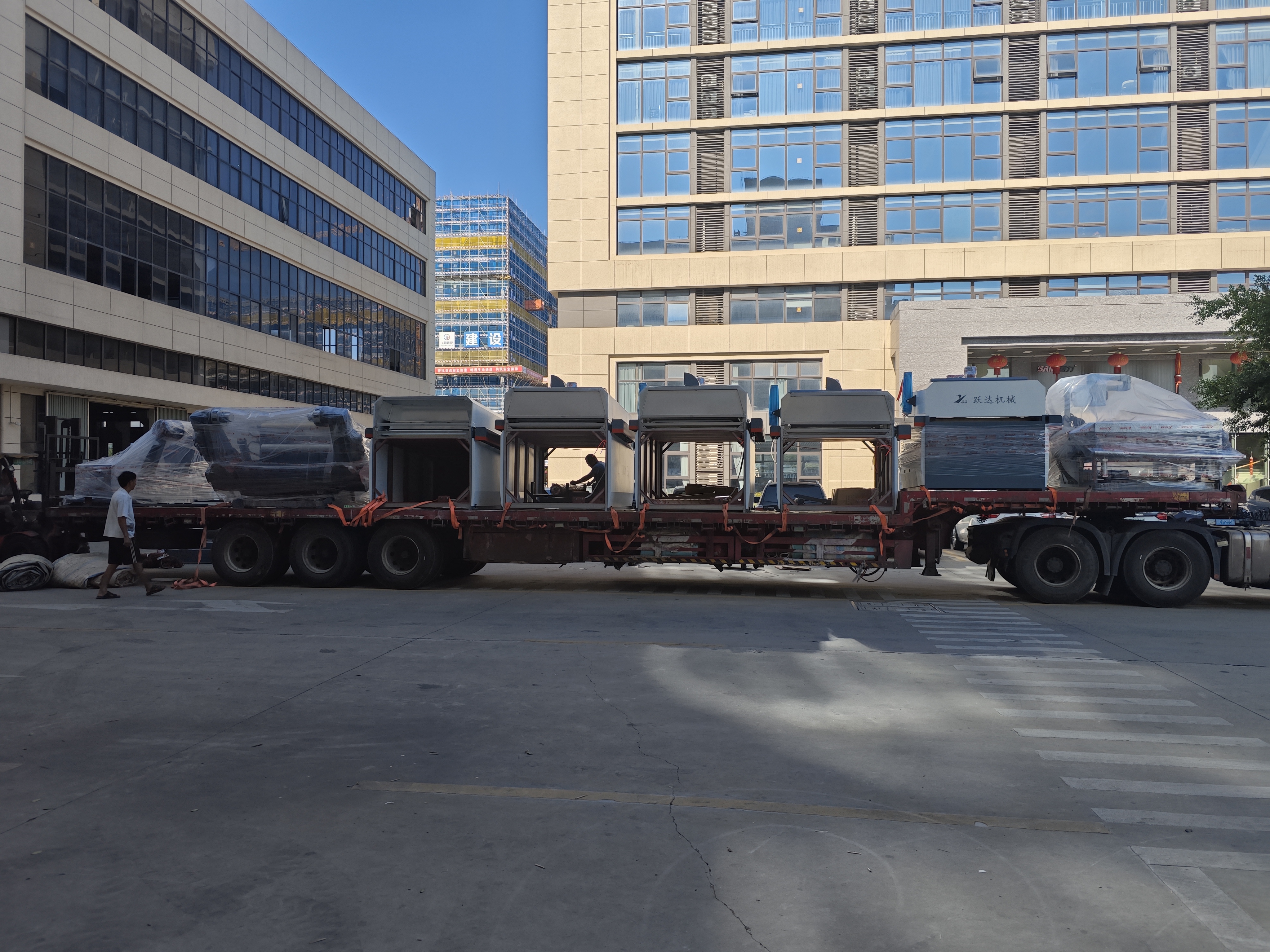 Multiple trucks loaded with YUEDA packaging machinery ready for global delivery