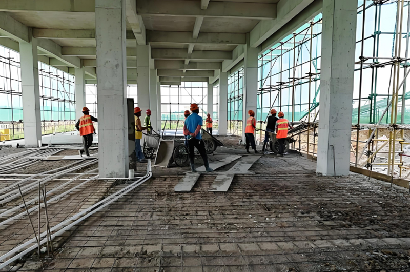 Concrete construction requiring large labor input, shown as the alternative to prefabricated steel building delivery