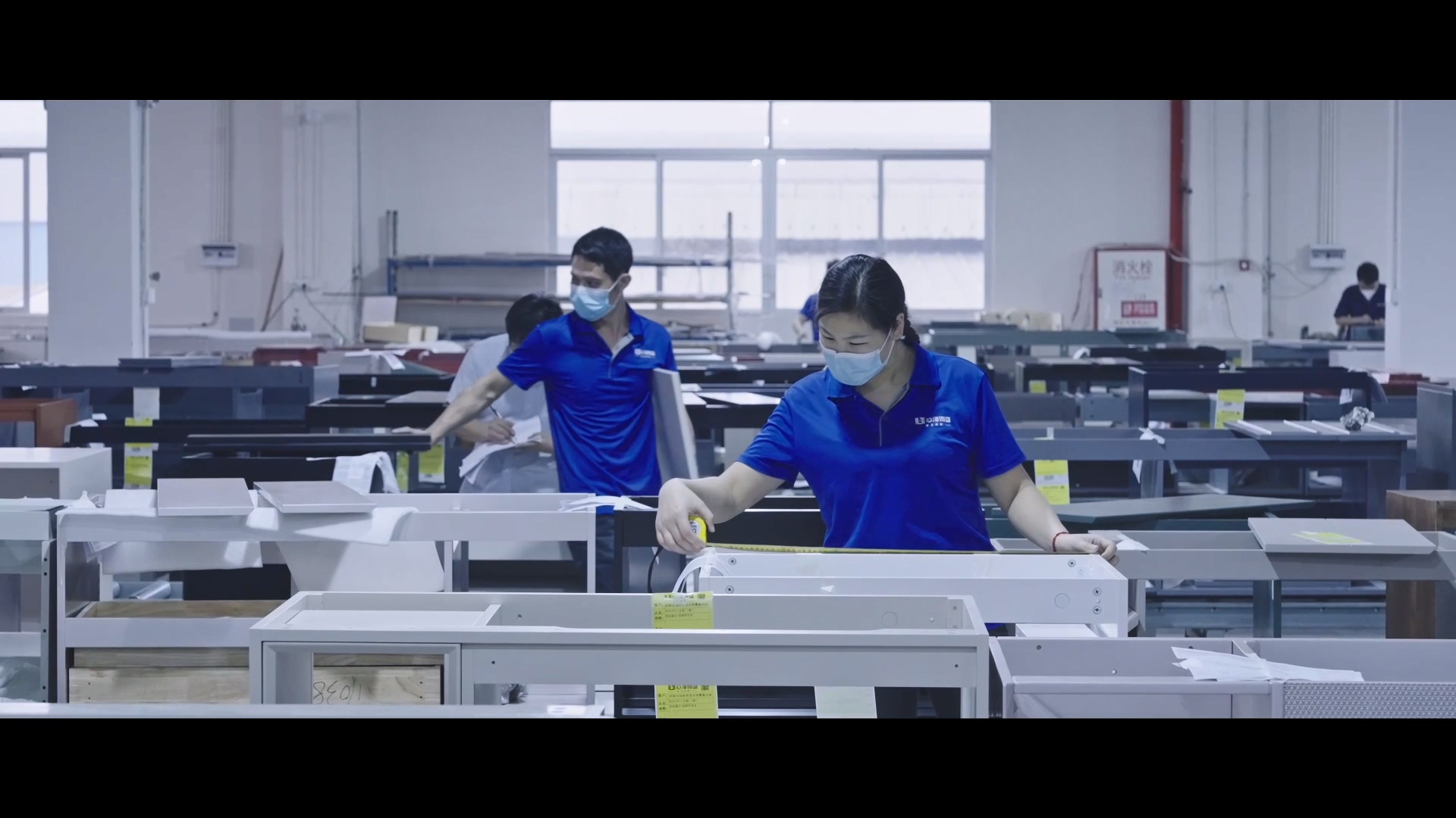 Busy production workshop at SHKL's manufacturing base with workers assembling shower door components