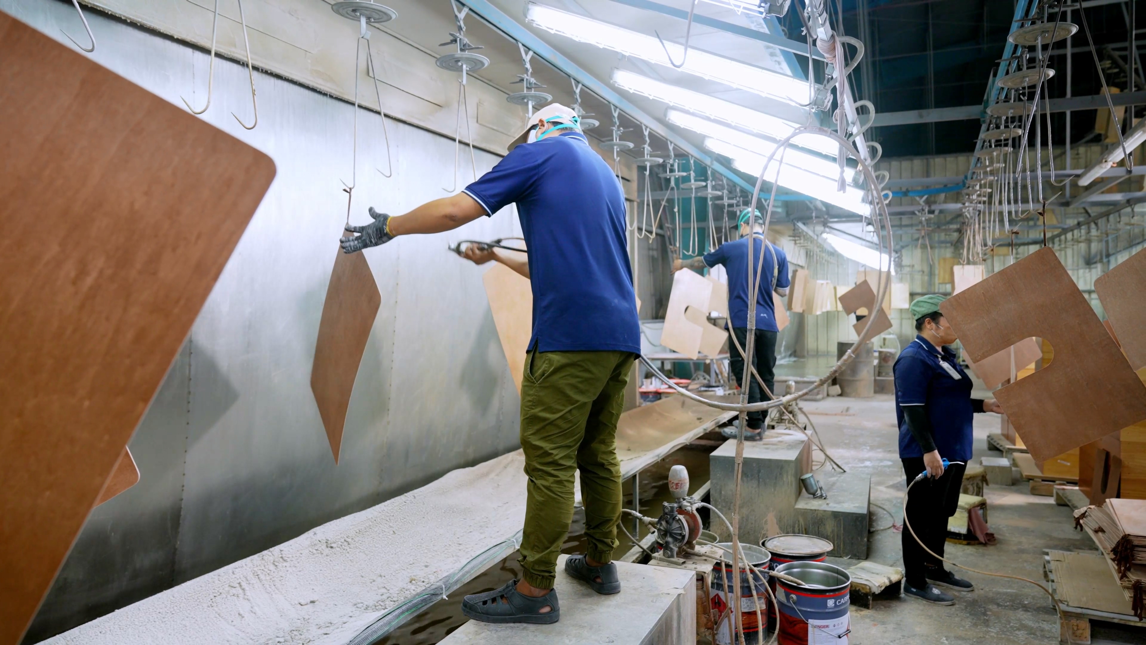 Spray painting line applying lacquer finishes to solid wood bathroom vanity components