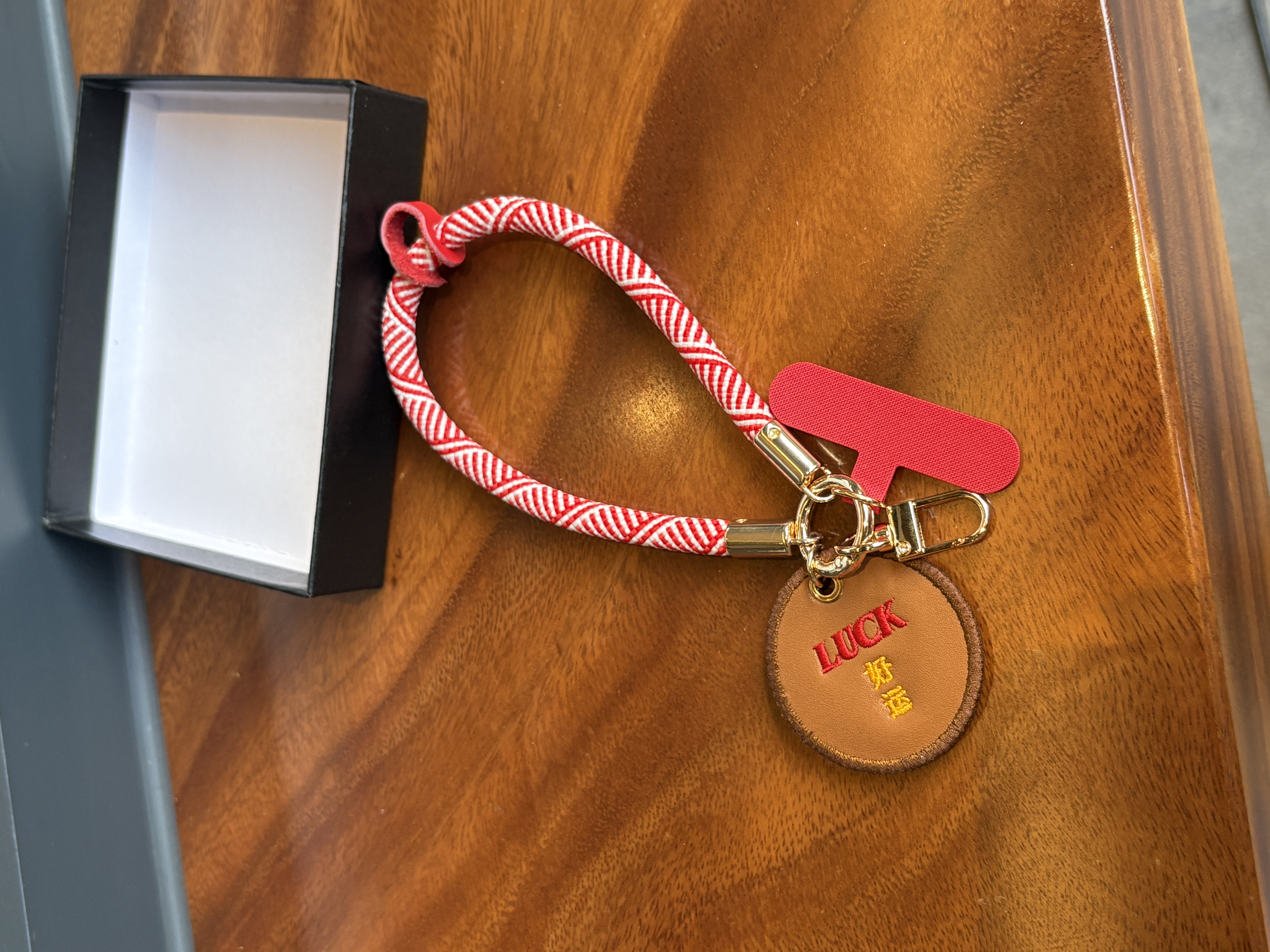 Leather embroidery craft on a custom phone charm and bag charm produced by a leather accessories factory