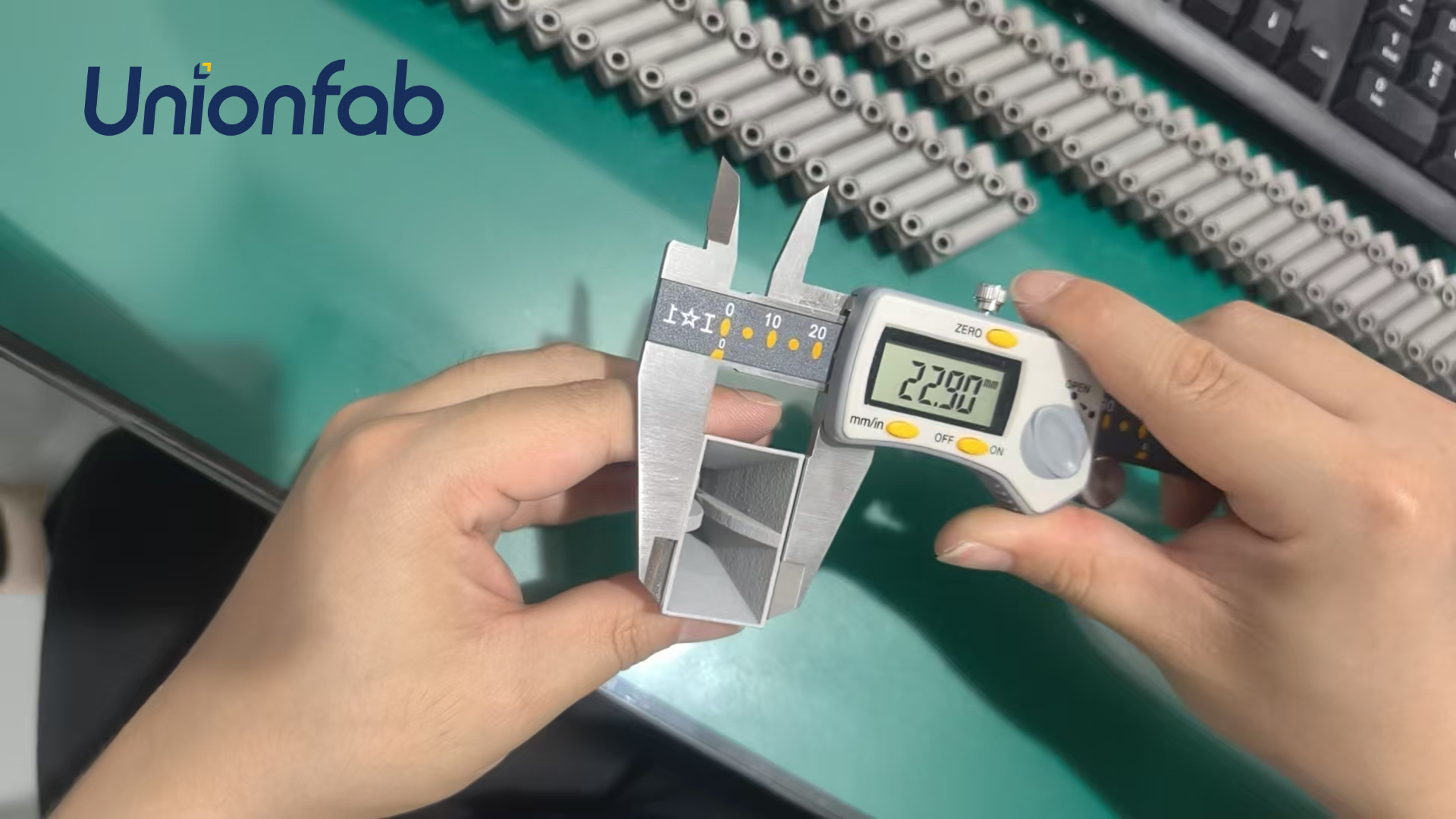 Unionfab inspecting square parts with digital caliper for thin-wall flatness