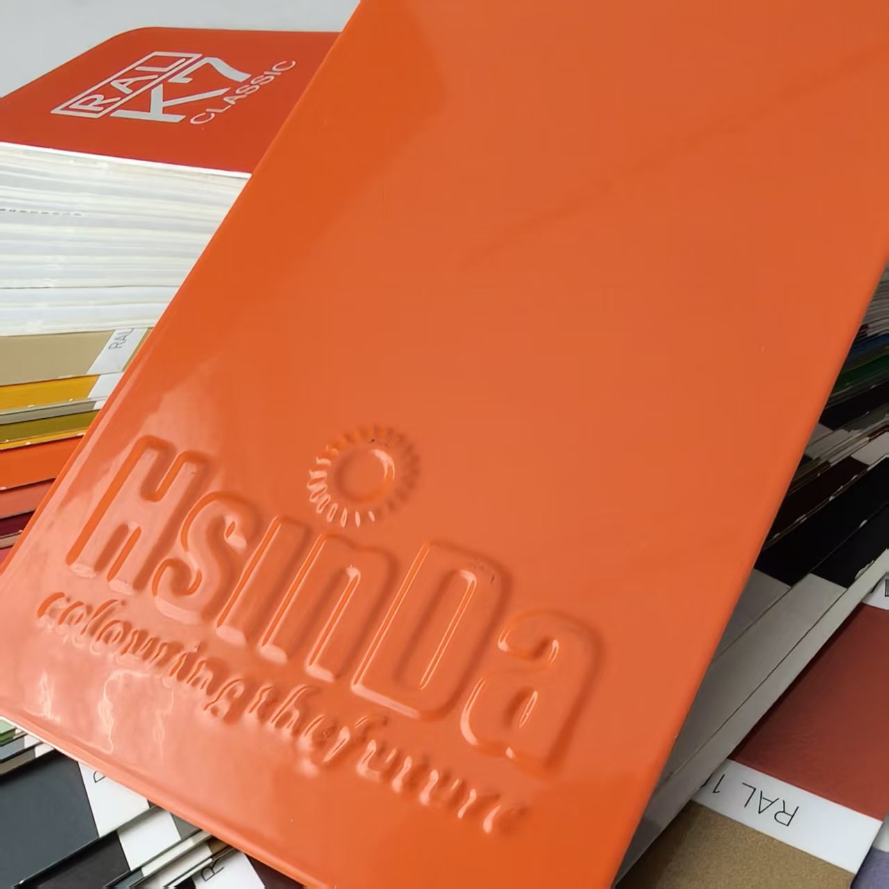 High gloss orange powder coating finish on a metal panel for construction and decoration projects