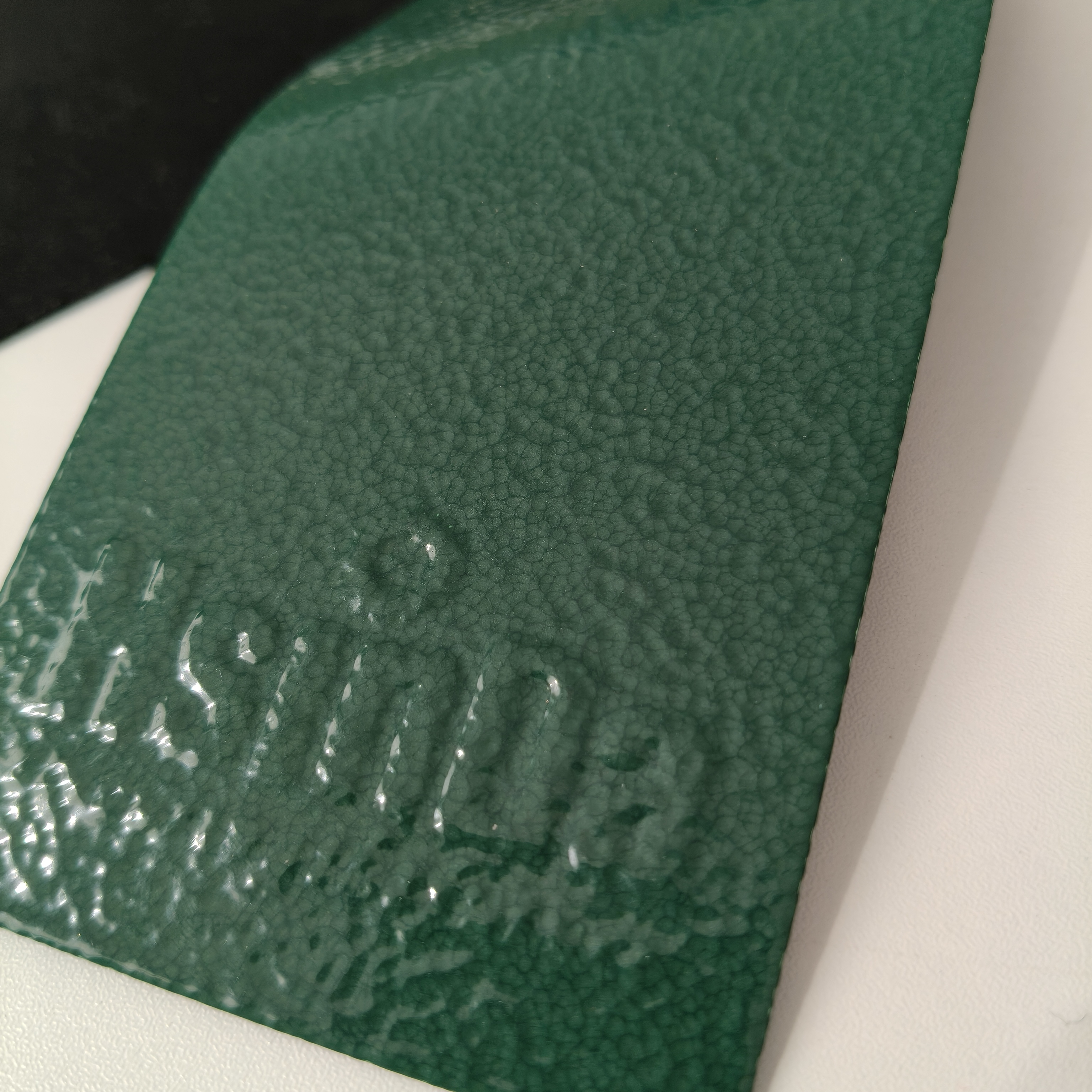Close view of hammer tone powder coating texture on a coated metal panel
