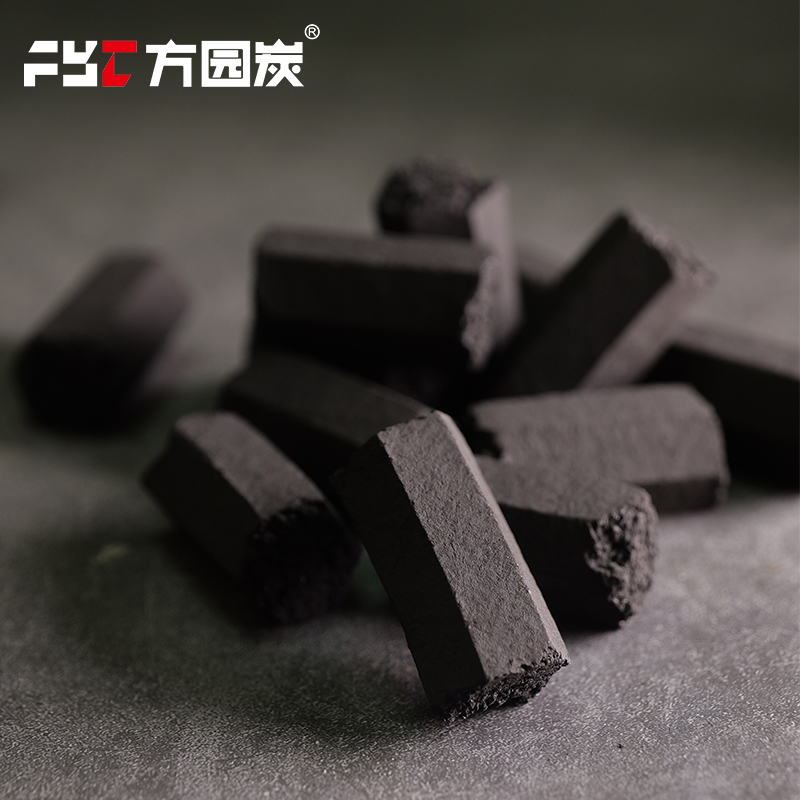 Hexagonal hookah charcoal pieces stacked in a production setting