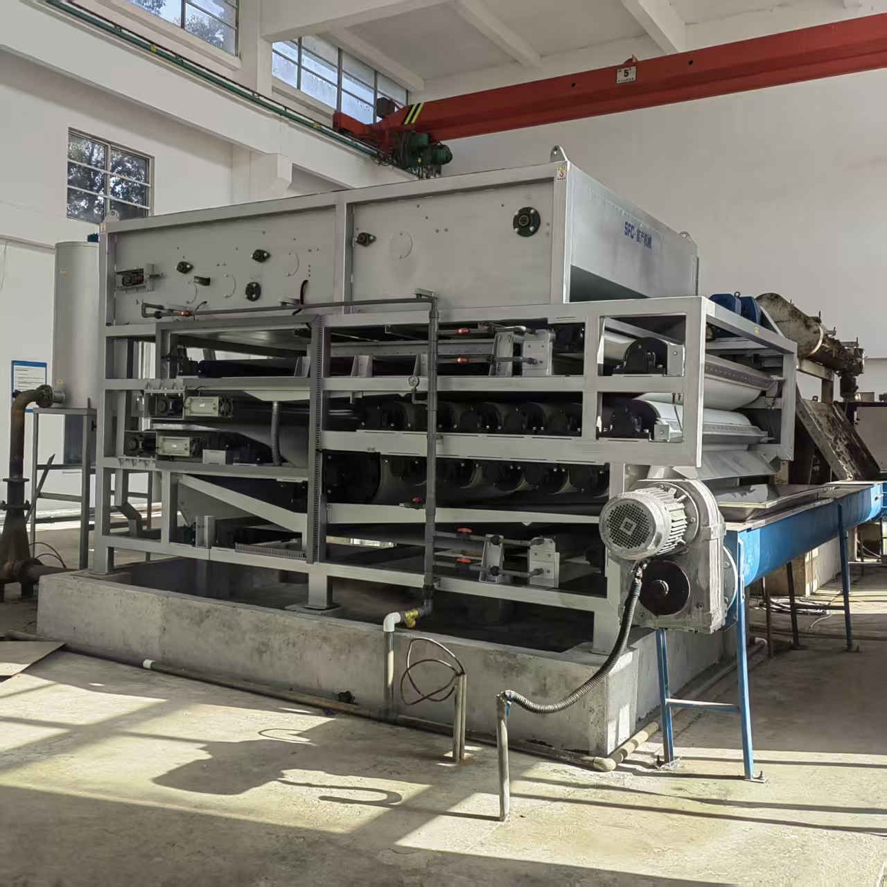 City sewage treatment plant site with integrated thickener-dewaterer machine in operation