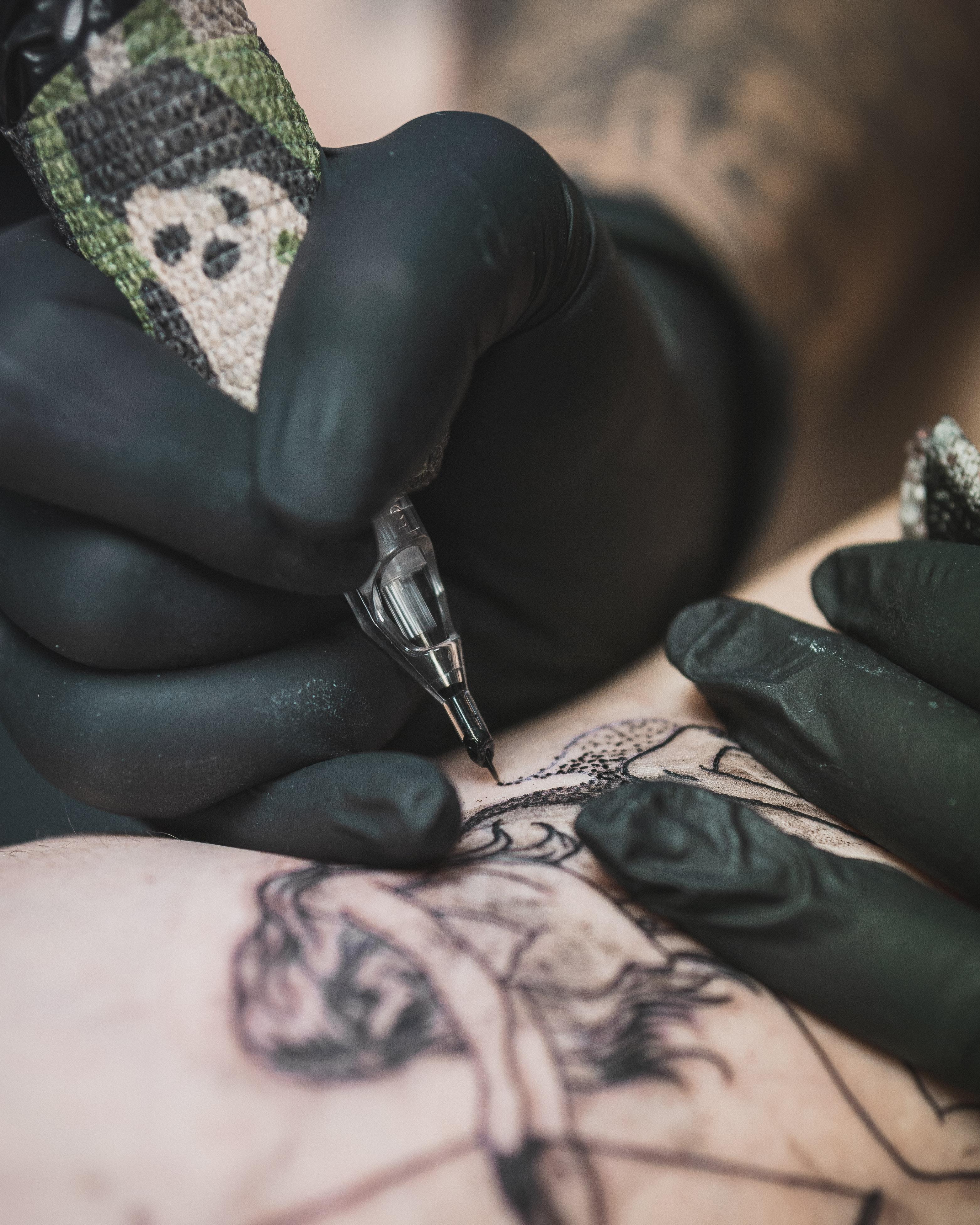 Professional tattoo artist working with cartridge needles