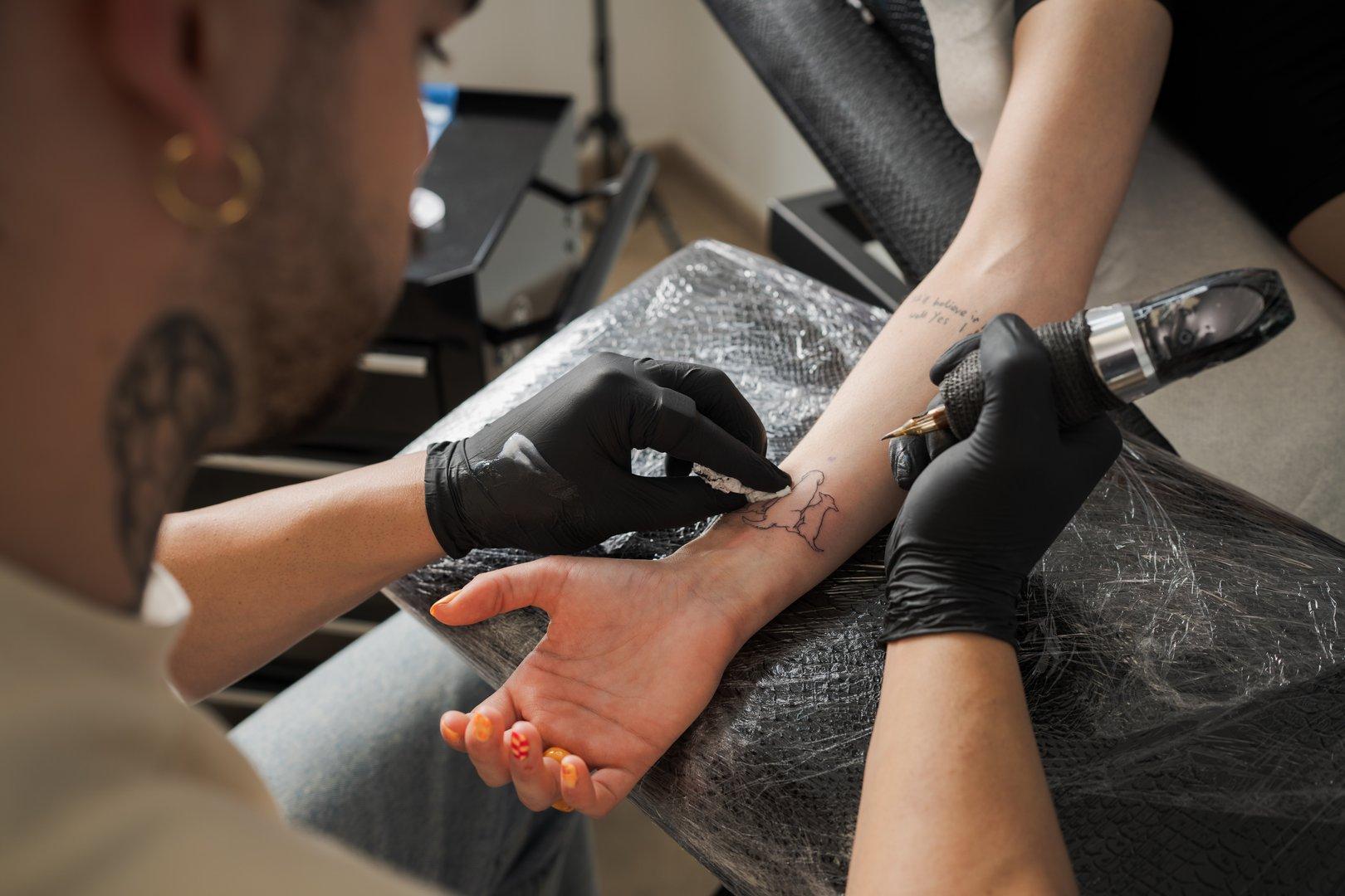Professional tattoo artist working with a tattoo cartridge needle in a studio