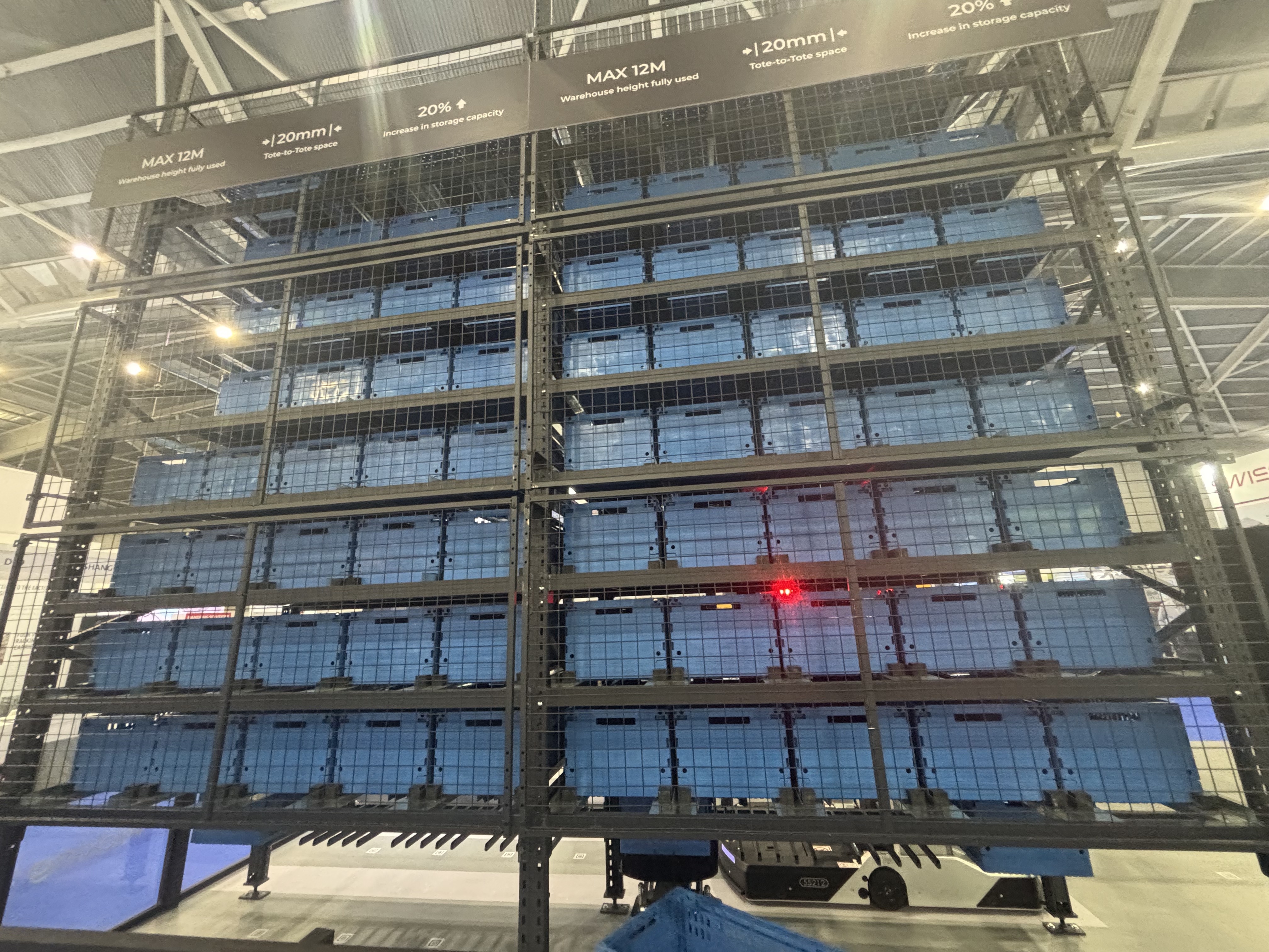 Automated warehouse scene with plastic totes moving on conveyor and ASRS systems