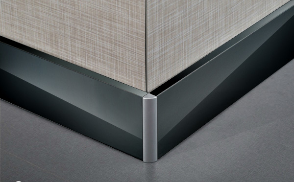 Stainless steel skirting board used as edge finishing trim in an architectural interior