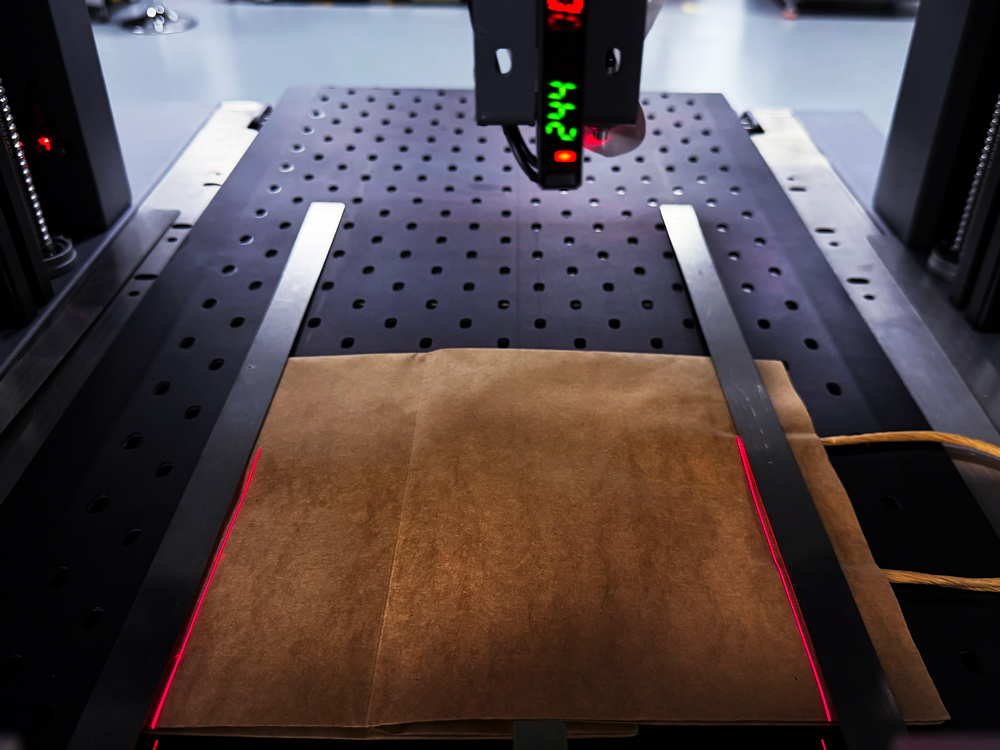Far-infrared laser guides facilitate rapid positioning of printing materials.