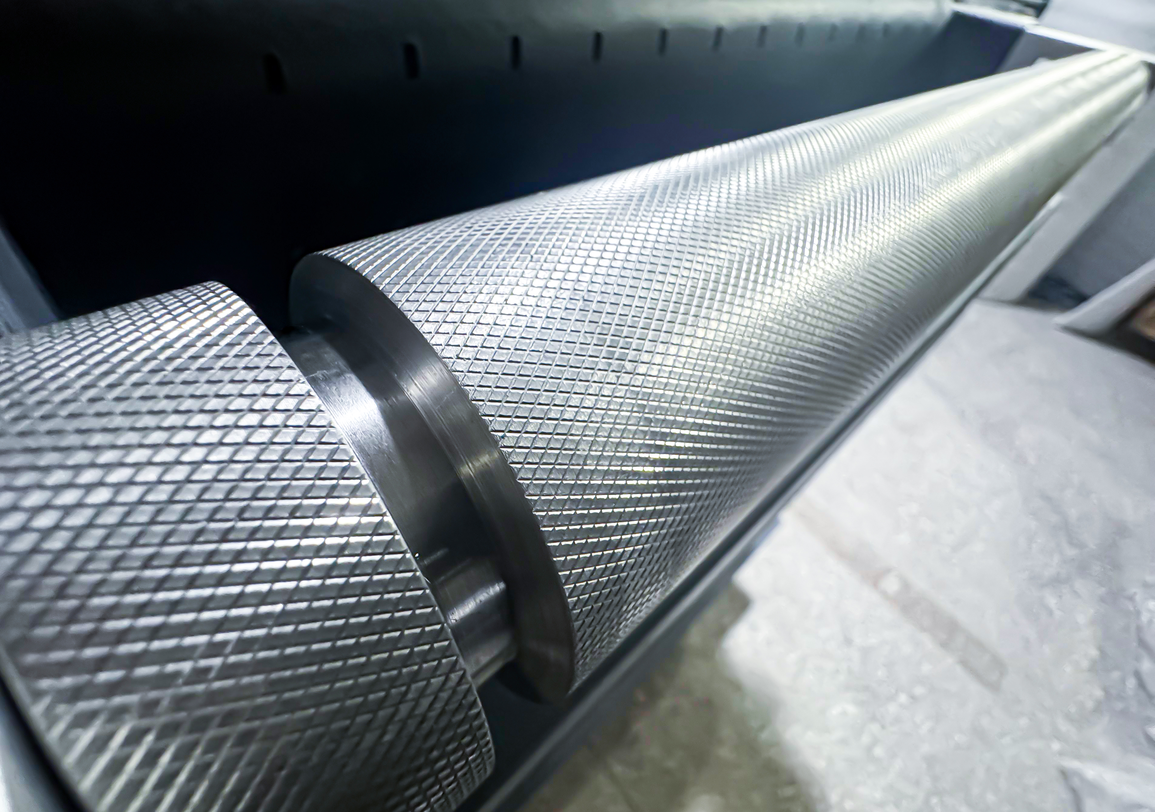 The knurled surface finish on the motion rollers ensures smooth and slip-free material feeding.