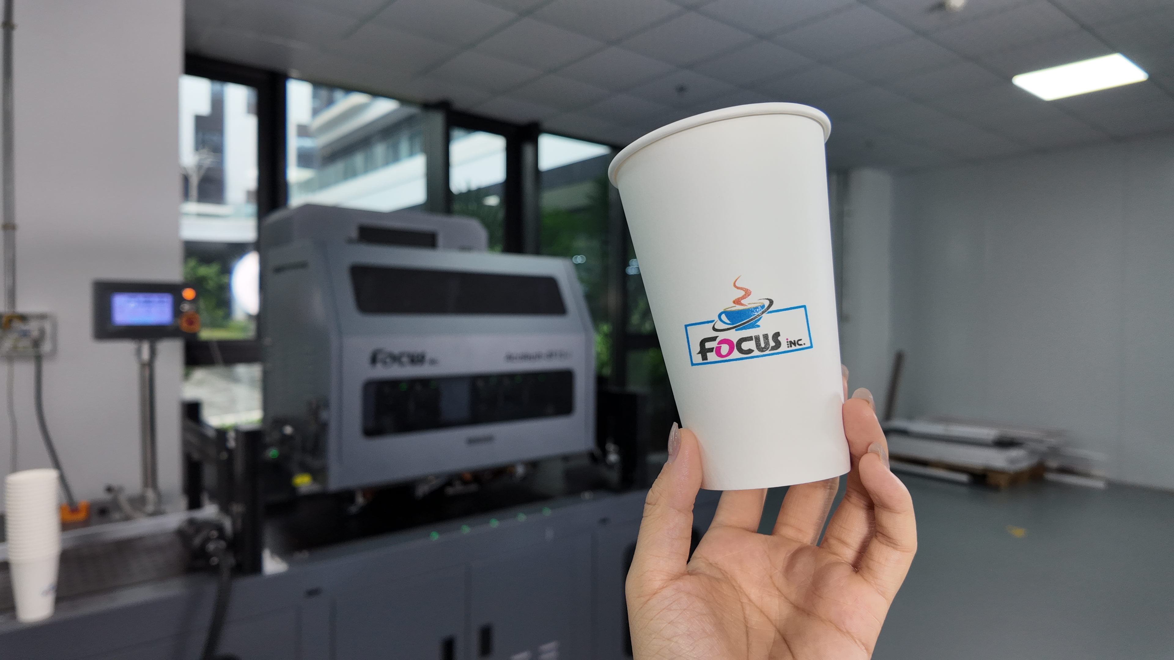 Single pass printer producing customised full-colour logos on paper cups and food-service containers