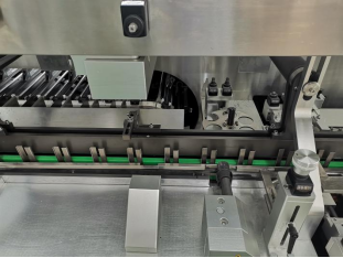 Servo-controlled carton pressing and height adjustment device on a high-speed cartoning machine