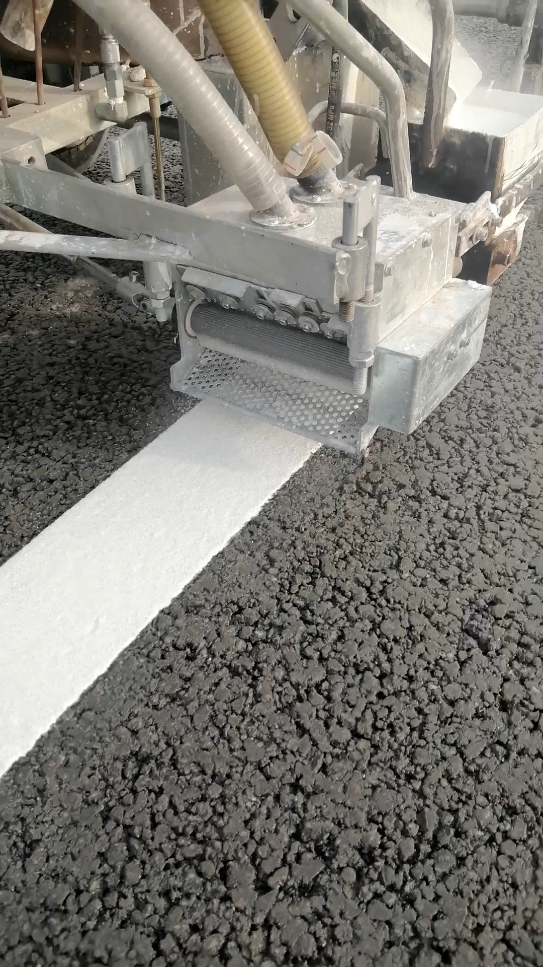 Road construction scene with reflective glass beads application