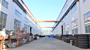Side exterior of the production workshop, raw material stacking and handling zone outside the workshop gate.