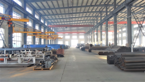 Interior of the main manufacturing workshop, with production lines for irrigation tower carts and truss parts.