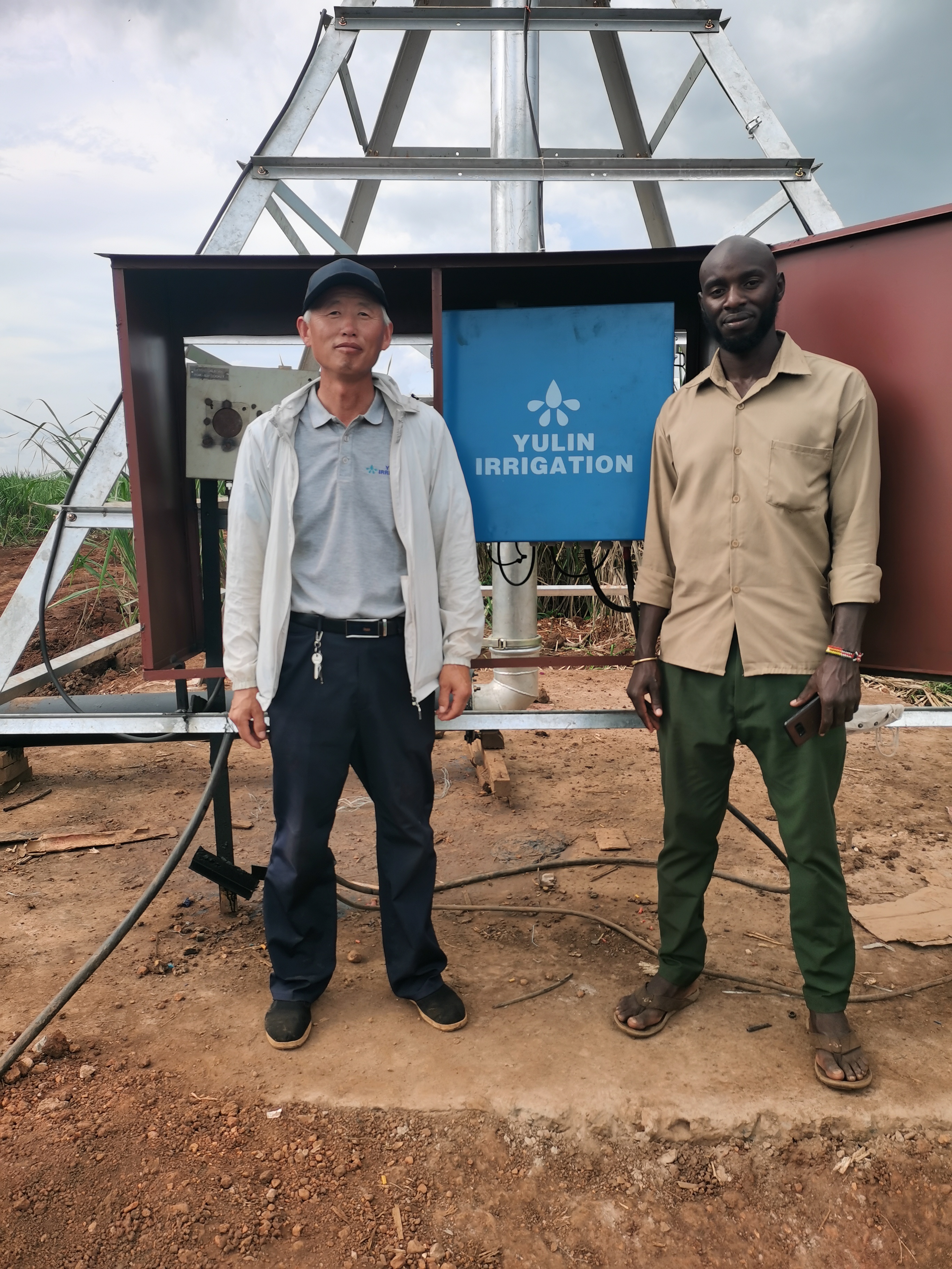Engineer providing on-site installation guidance and operator training for an installed center pivot irrigation system at an overseas farm