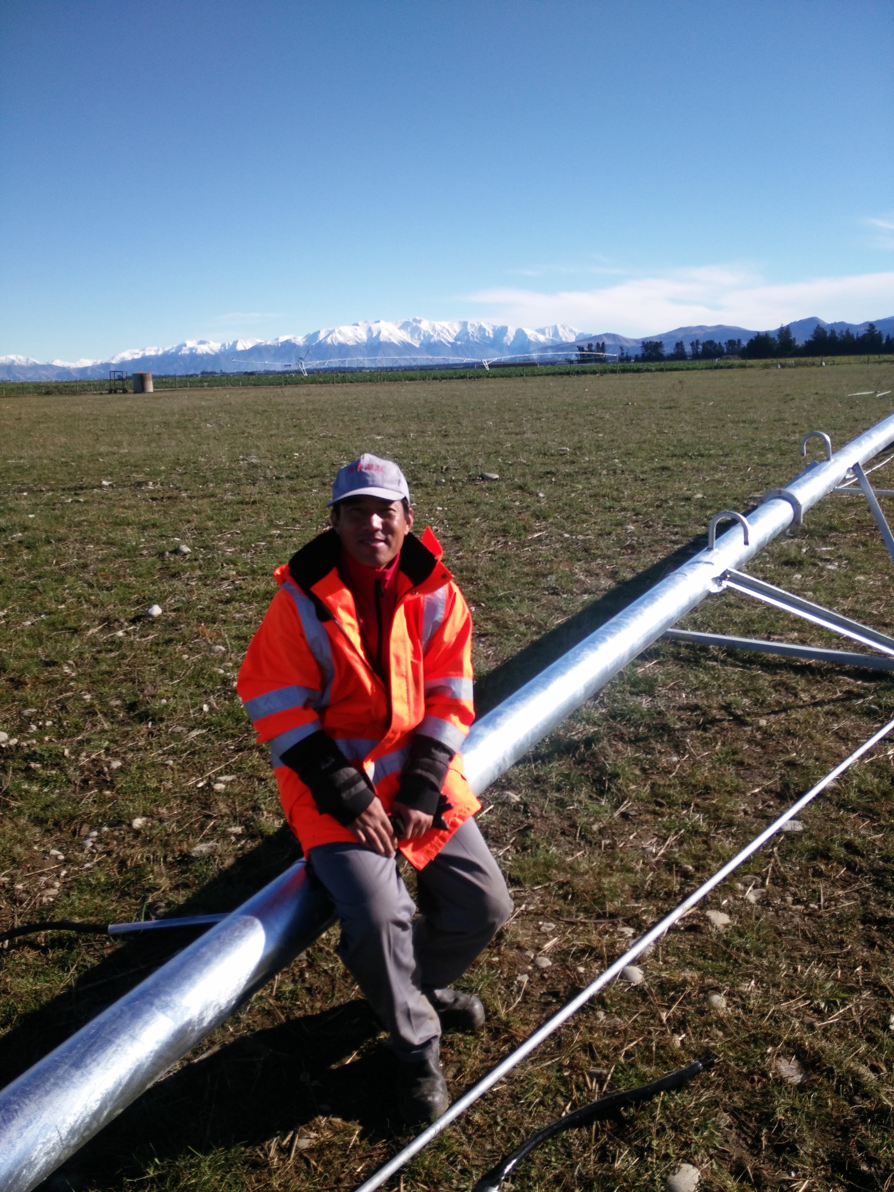 Center pivot irrigation machine operating on a New Zealand grass farm, demonstrating long service life in pasture irrigation