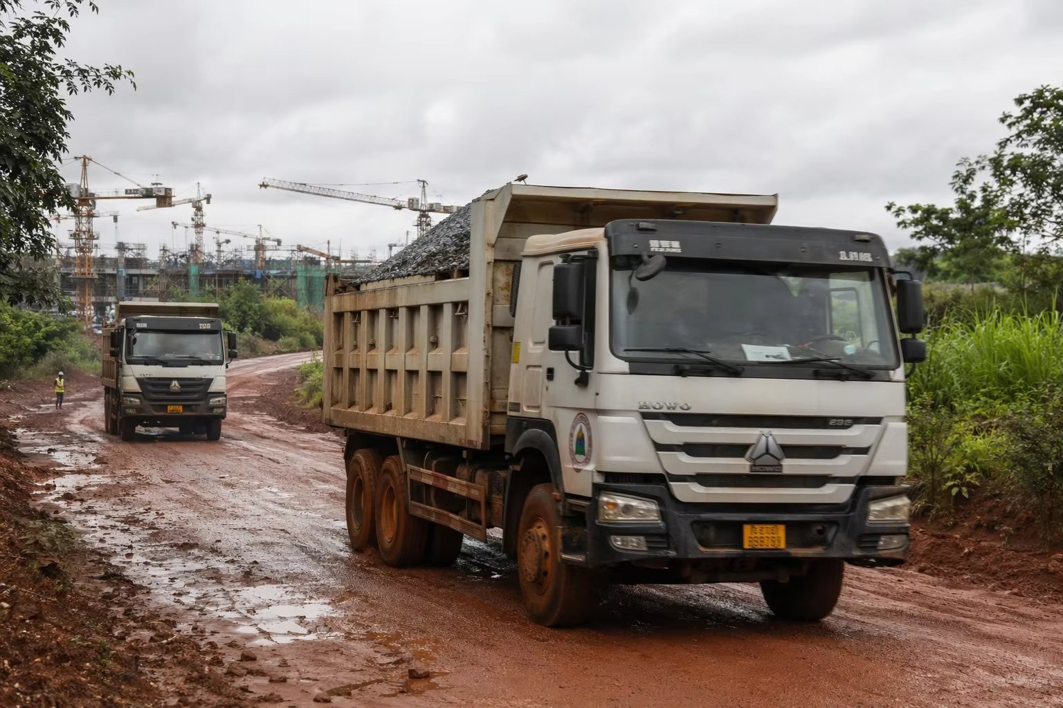 Dump truck working on a muddy construction road during an urban infrastructure project