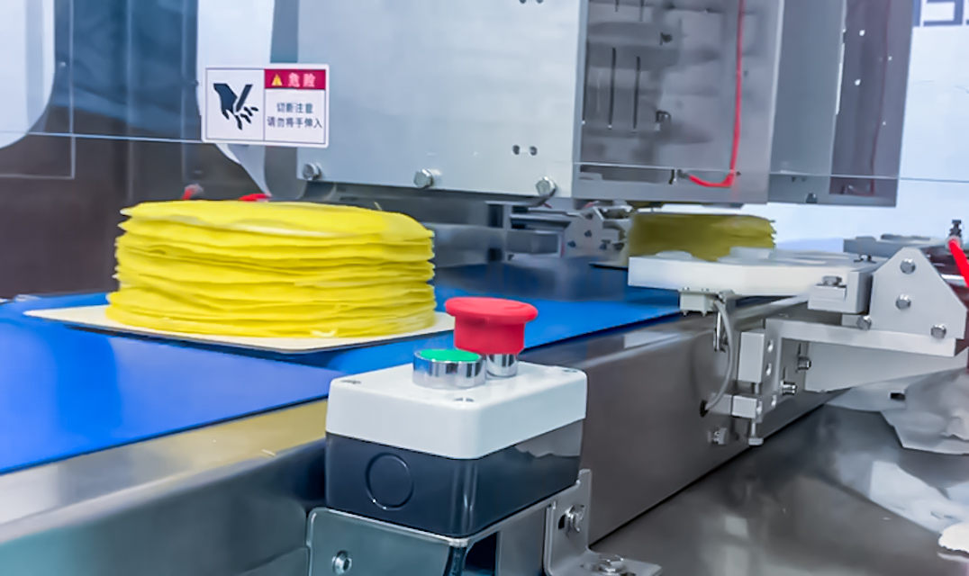 Large-production inline round cake cutting machine on a bakery production line