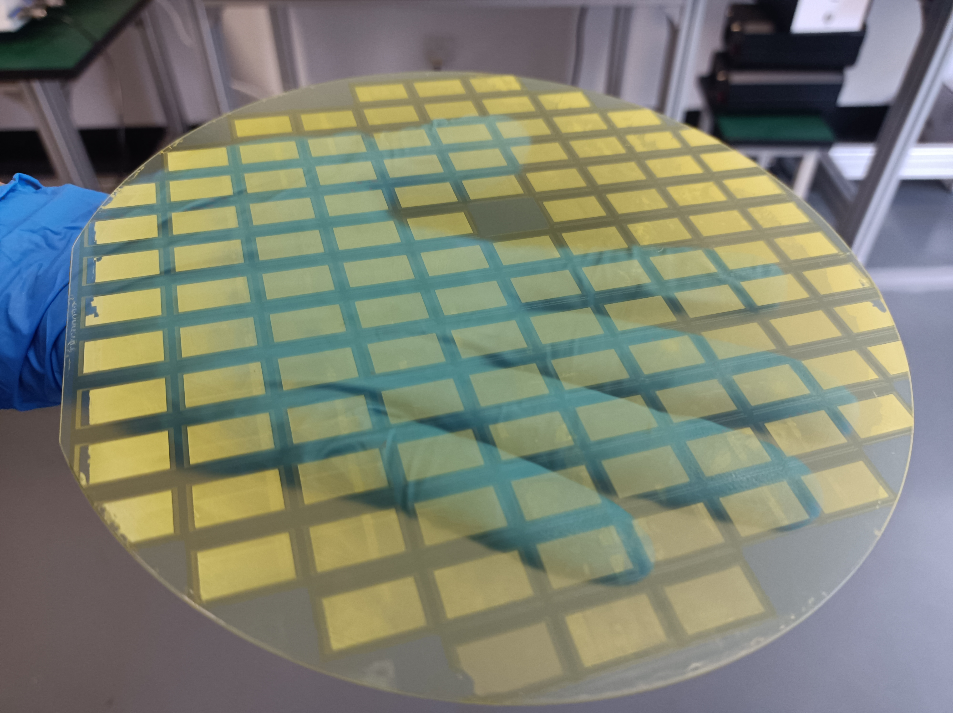Ultrasonic sprayer depositing photoresist coating onto a semiconductor chip surface