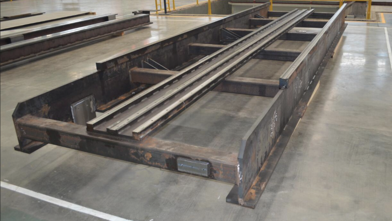 Large welded equipment base fabricated as a heavy steel frame before machining