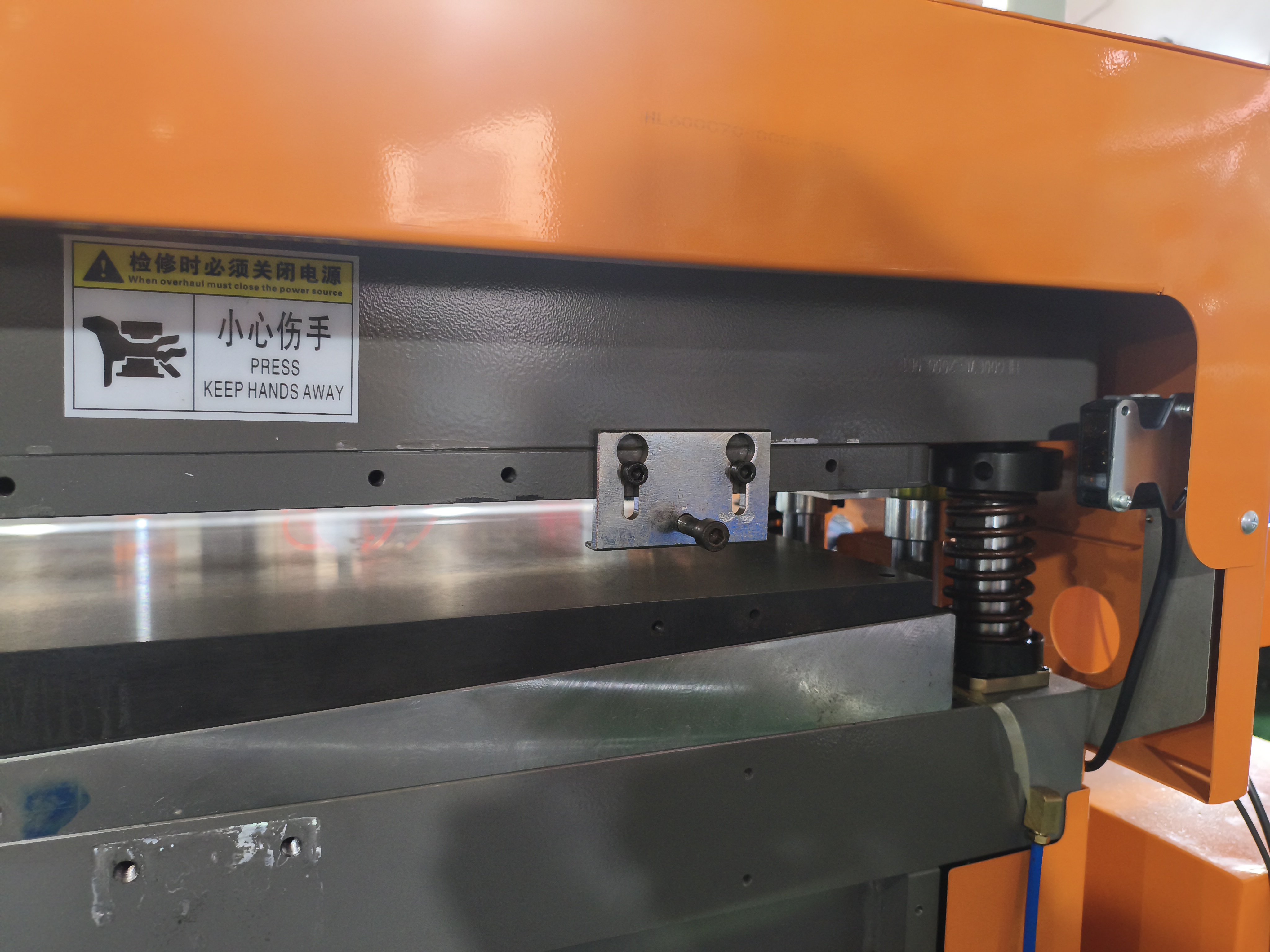Anti-pinch safety guard arrangement on a bag making and stamping machine