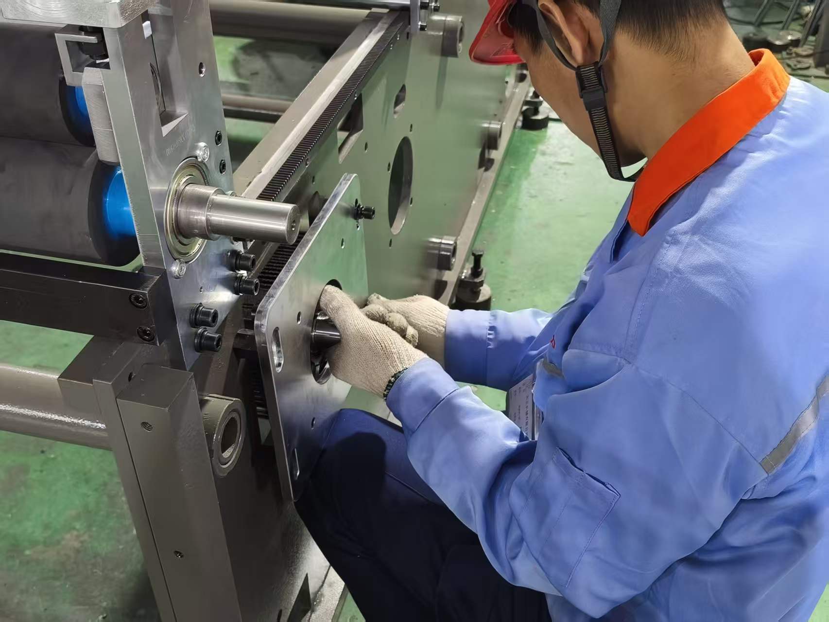 Engineers assembling a plastic bag making machine on the factory floor