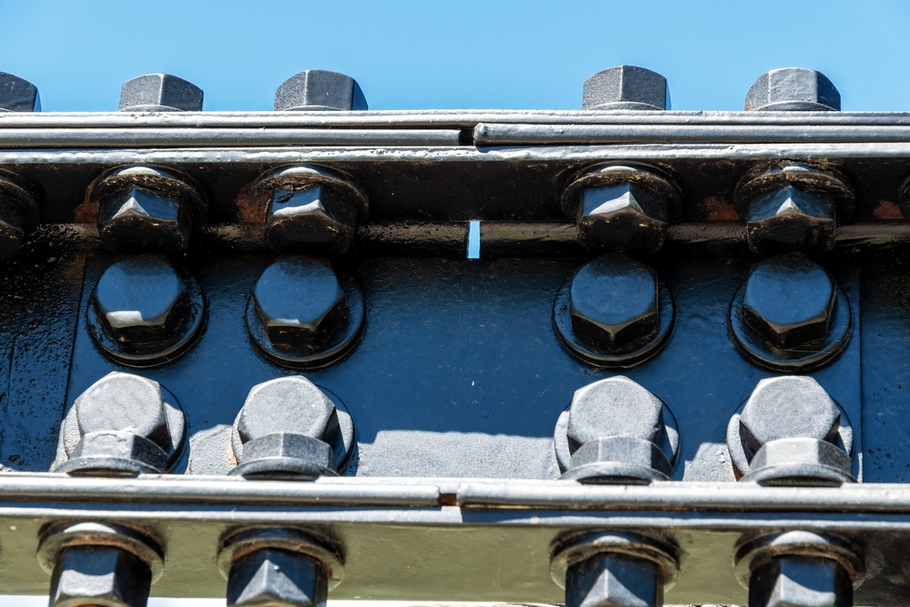 Steel truss bridge joint — static permanent fastening under outdoor exposure Bolt connection scene at steel truss bridge joints using carbon steel hex bolts