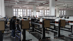 Technicians work on several Xinflying DTF printers with their upper covers open for assembly and inspection.
