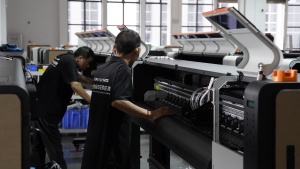 A technician installs and checks internal components inside an open Xinflying DTF printer.
