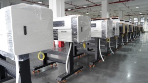 A long row of completed Xinflying DTF printers is wrapped and prepared for storage or international shipment.