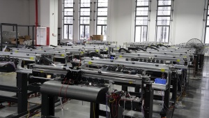 Rows of partially assembled Xinflying DTF printer frames await wiring, component installation, and final testing.