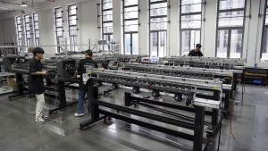 Xinflying technicians connect and inspect internal components across several DTF printers on the assembly line.