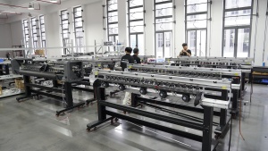 Technicians assemble and test multiple Xinflying DTF printer mechanisms in an orderly production area.