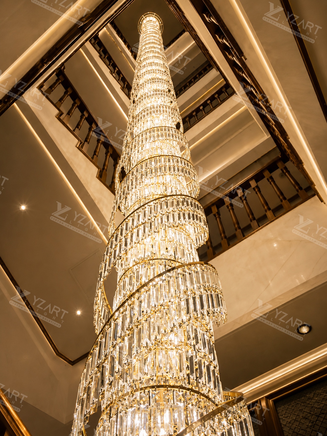 Rotating tiered rectangular crystal rod pendant light installed in a multi-storey hotel lobby