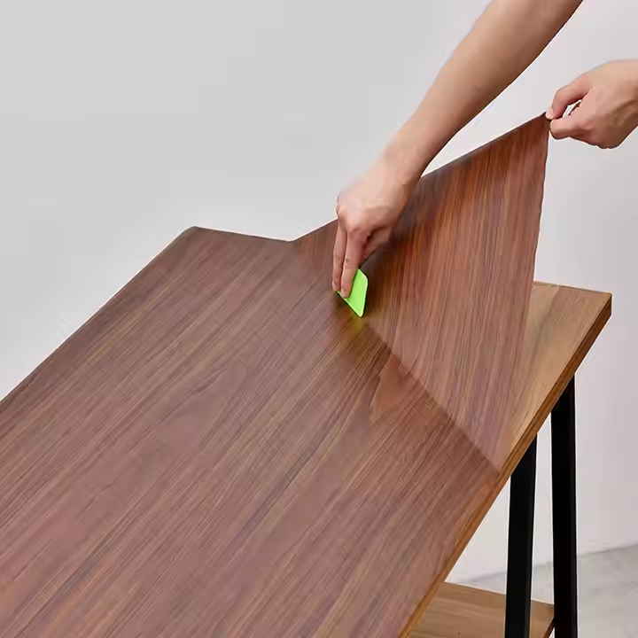 Wood grain self-adhesive PVC film applied to a furniture table top