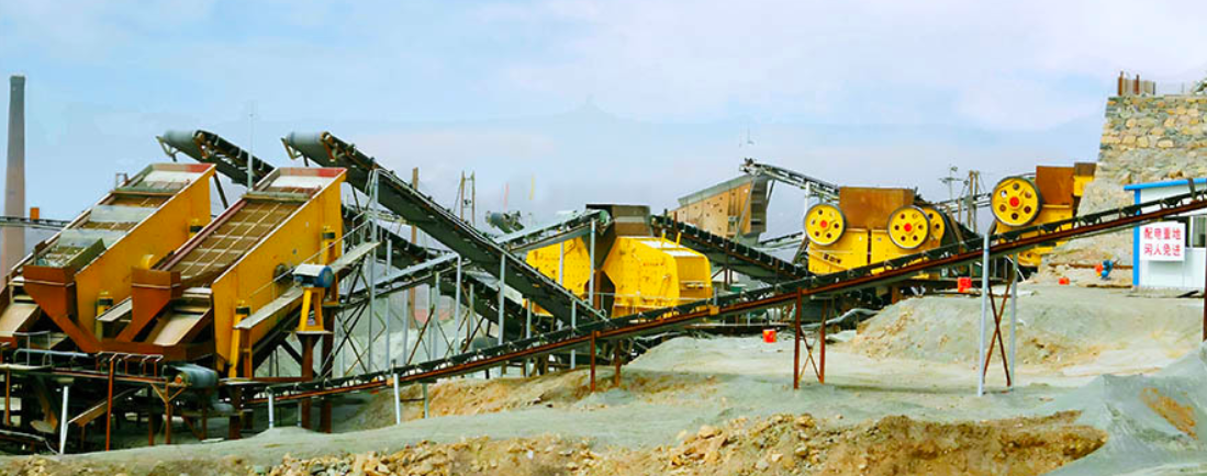 Hard-rock crushing plant site with primary jaw crushing, secondary cone crushing and aggregate stockpiles
